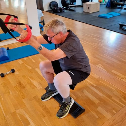 Mand laver dybe squats på GLAD træning Mand laver dybe squats i GLAD program